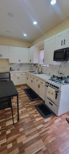 a kitchen with white appliances and a wooden floor at Oceanview Suites in Saint Georgeʼs