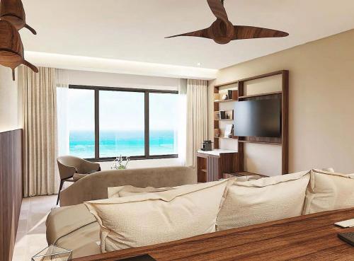 a living room with a couch and a flat screen tv at Secrets Mirabel Cancún Resort & Spa in Cancún