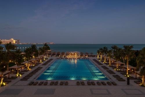 a view of the pool at the resort at night at The St. Regis Doha in Doha