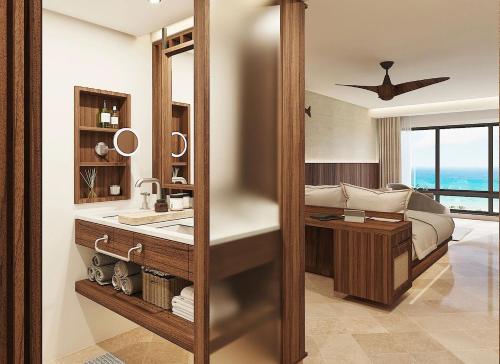 a bathroom with a sink and a bed and a mirror at Secrets Mirabel Cancún Resort & Spa in Cancún