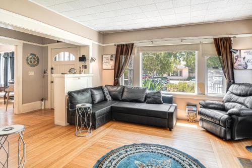 a living room with a black leather couch at Miracle Mile Stay Classic Stockton Home with Yard! in Stockton
