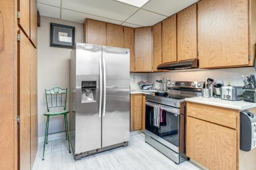 a stainless steel refrigerator in a kitchen with wooden cabinets at Miracle Mile Stay Classic Stockton Home with Yard! in Stockton