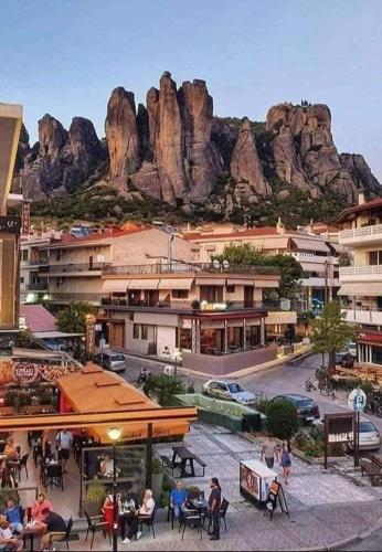 a group of people sitting at tables in front of a mountain at Meteora Grande luxury suite & spa villa in Kalabaka