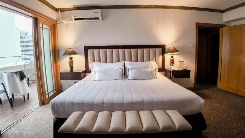 a bedroom with a large white bed with a large window at Hotel Miramar in Lima