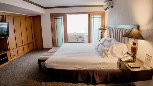 a hotel room with a large bed and a television at Hotel Miramar in Lima