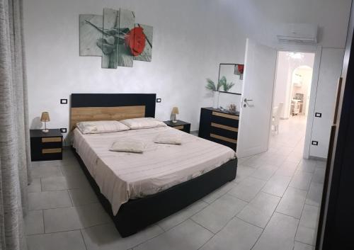 a bedroom with a large bed and a white tile floor at My house in Piombino