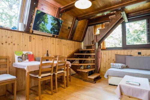 a room with a dining table and a tv on the wall at Little paradise house in Lič