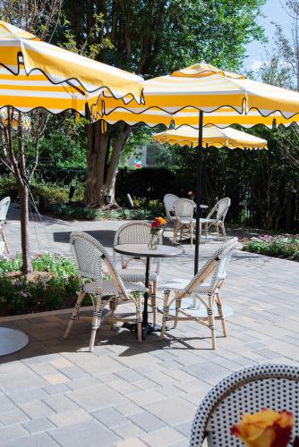 a table and chairs under an umbrella on a patio at La Colombe d'Or Hotel in Houston