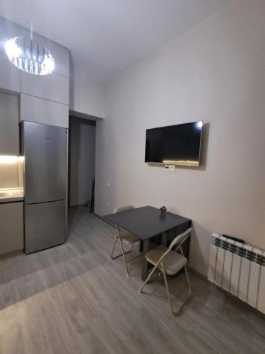 ein Esszimmer mit Tisch und Kühlschrank in der Unterkunft Appartamento in Baku