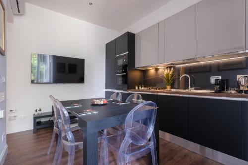 una cocina con mesa negra y sillas en L&K Prestige House with Parking - Sant'Orsola, en Bolonia