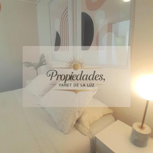a sign in a room with a bed and a lamp at Departamento Central Vip in Antofagasta