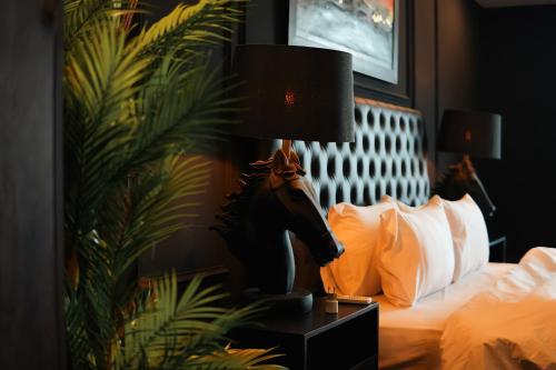 a bedroom with a bed with a horse lamp on a night stand at Gold Crest Mall Luxury Apartments by NestNow in DHA Phase 4 Lahore in Lahore