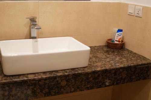 a white sink on a counter in a bathroom at Gold Crest Mall Luxury Apartments by NestNow in DHA Phase 4 Lahore in Lahore