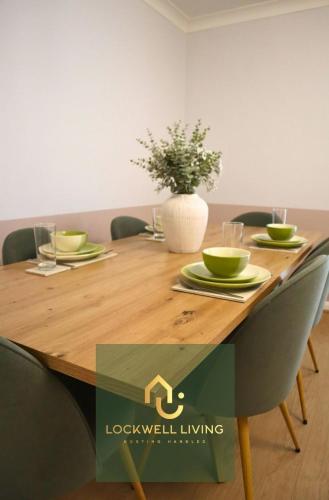 a wooden table with green dishes and a vase on it at Chalfont Haven 