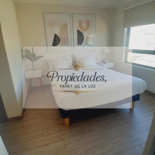 a sign on a bed in a room at Departamento Central Vip in Antofagasta