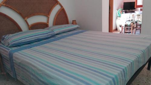ファヴィニャーナにあるCasa Vacanze Luciaの青と白のストライプのベッドカバーが備わるベッド1台