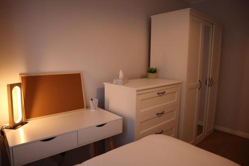 a bedroom with a white dresser and a mirror at Chalfont Haven 