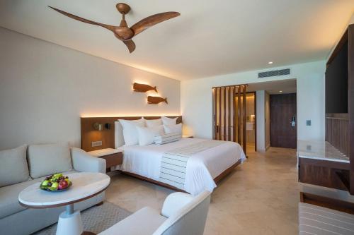 a hotel room with a bed and a couch at Secrets Mirabel Cancún Resort & Spa in Cancún