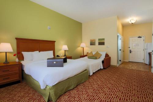 a hotel room with two beds and a laptop on the bed at TownePlace Suites Lubbock in Lubbock