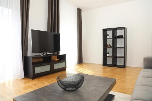 a living room with a television and a table at Ferienglück Rosenheim in Rosenheim