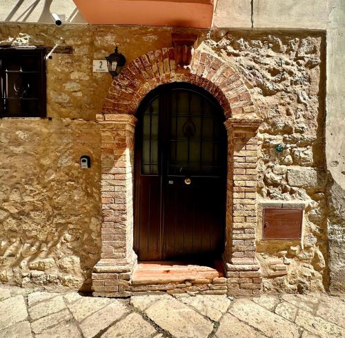 an entrance to a stone building with a wooden door at Le Nereidi in Fondi