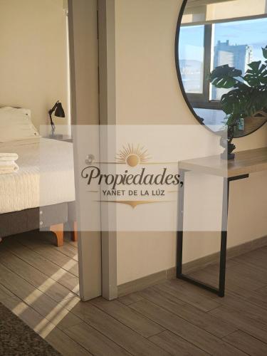a sign in a room with a bed and a mirror at Departamento Central Vip in Antofagasta