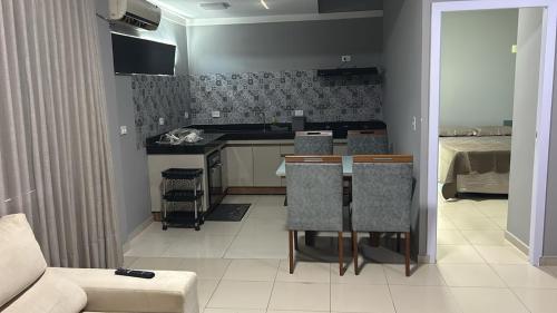 a kitchen and living room with a table and chairs at Flat Eduardus in Palmas
