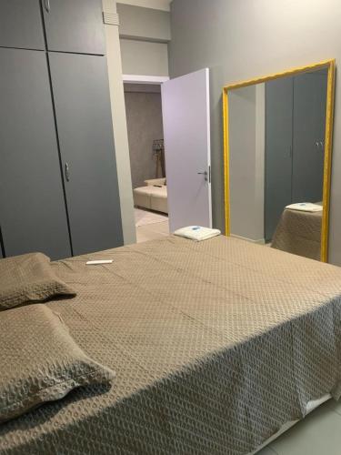 a bedroom with a large bed with a mirror at Flat Eduardus in Palmas