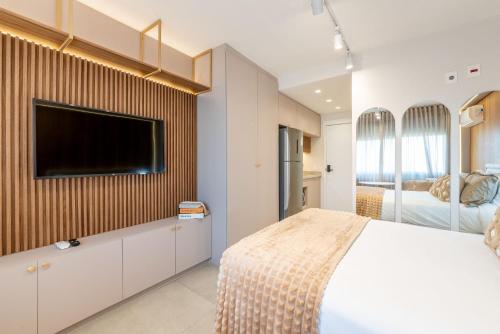 a bedroom with a bed and a tv on a wall at Skyline Parque Moinhos by LikeHome in Floresta