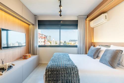 a bedroom with a large bed and a window at Skyline Parque Moinhos by LikeHome in Floresta