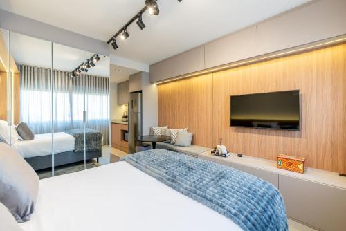 a hotel room with a bed and a flat screen tv at Skyline Parque Moinhos by LikeHome in Floresta