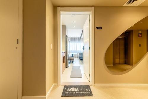 a hallway with an open door and a mirror at Skyline Parque Moinhos by LikeHome in Floresta
