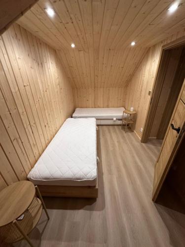 a small room with a bed in a wooden cabin at Mazurski Chill House in Małkinie