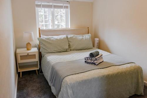 ein kleines Schlafzimmer mit einem Bett mit Fenster in der Unterkunft Old Castle Cottage Retreat in Oxford