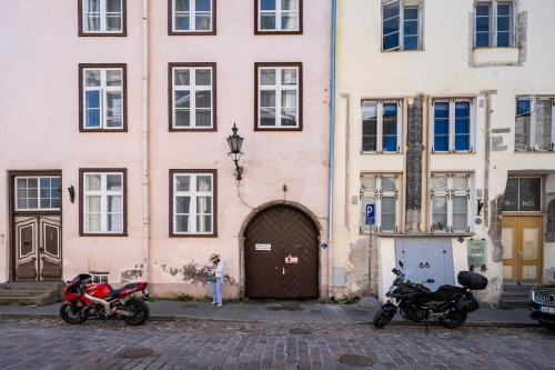 two motorcycles parked in front of a building at 15th Century Flat with Parking, High Ceilings in Tallinn