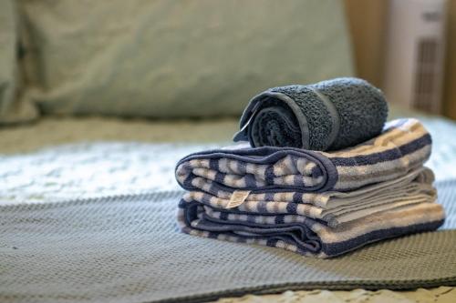ein Stapel Handtücher auf einem Bett in der Unterkunft Old Castle Cottage Retreat in Oxford