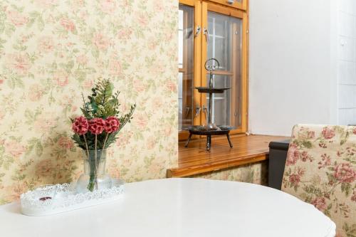 a vase of flowers on a table in a room at 15th Century Flat with Parking, High Ceilings in Tallinn