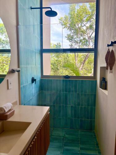 a bathroom with a green tiled shower with a window at New! Aflora Retreat Tulum, Loft With Pool And Gym in Tulum