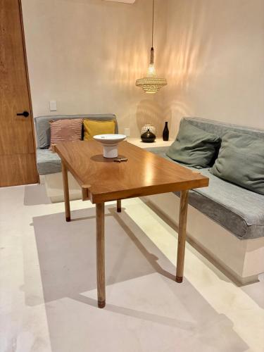 a living room with a wooden coffee table and a bed at New! Aflora Retreat Tulum, Loft With Pool And Gym in Tulum