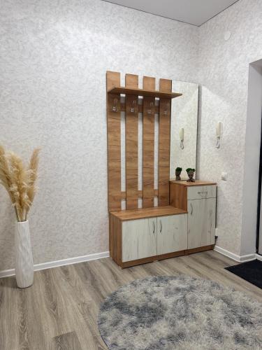 a dressing room with a mirror and a wooden cabinet at Уютная новая квартира в ЖК Береке 2 рядом с Kostanay Plaza in Kostanay