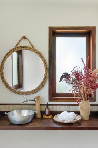 a bathroom counter with a sink and a mirror at Pousada Pais Tropical in Icaraí