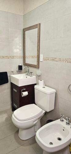 a bathroom with a white toilet and a sink at Entre Montañas - Vista Calma in Potrerillos