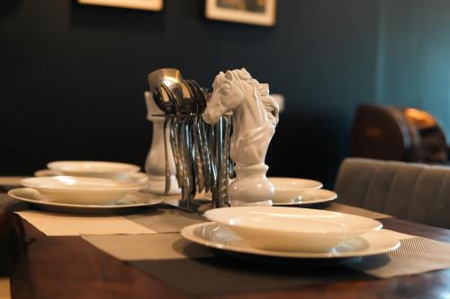 a table with plates and a white horse statue on it at Gold Crest Mall Luxury Apartments by NestNow in DHA Phase 4 Lahore in Lahore