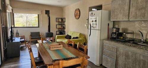 a kitchen and living room with a table and a refrigerator at Entre Montañas - Vista Calma in Potrerillos