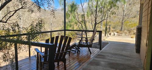 a porch with two chairs and a table and a window at Entre Montañas - Vista Calma in Potrerillos