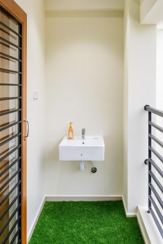 a bathroom with a white sink and green carpet at Brand New 3BR Condo 5 Min Walk to T Nagar Shopping in Chennai