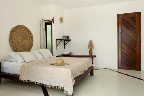 a bedroom with a bed with a hat on it at Pousada Pais Tropical in Icaraí