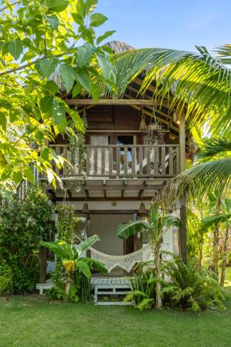 a house with a porch and a bench in front of it at Pousada Pais Tropical in Icaraí