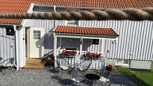 a patio with chairs and a building with flowers at Strömspärlan - Nordic Stay Strömstad in Strömstad