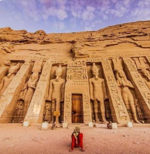 a person kneeling in front of an ancient building at Amon guest house in Abu Simbel